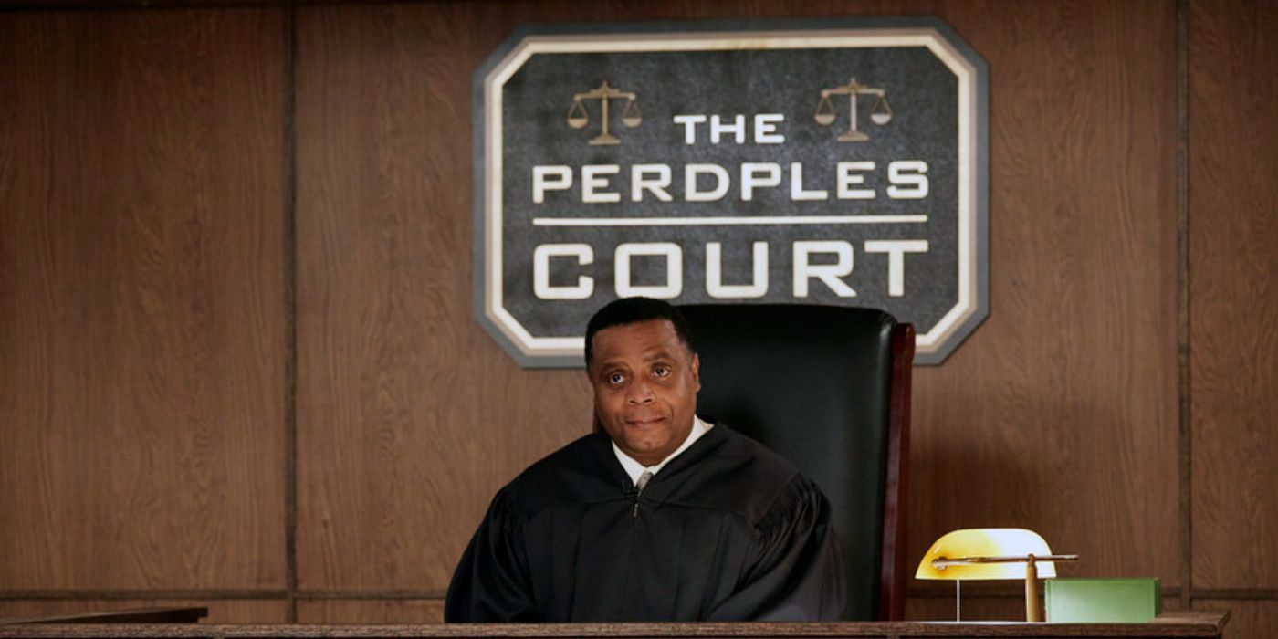 Jay Jackson sits at a judge&rsquo;s bench as Perd Hapley in the fictional show The Perdples Court on Parks and Rec.