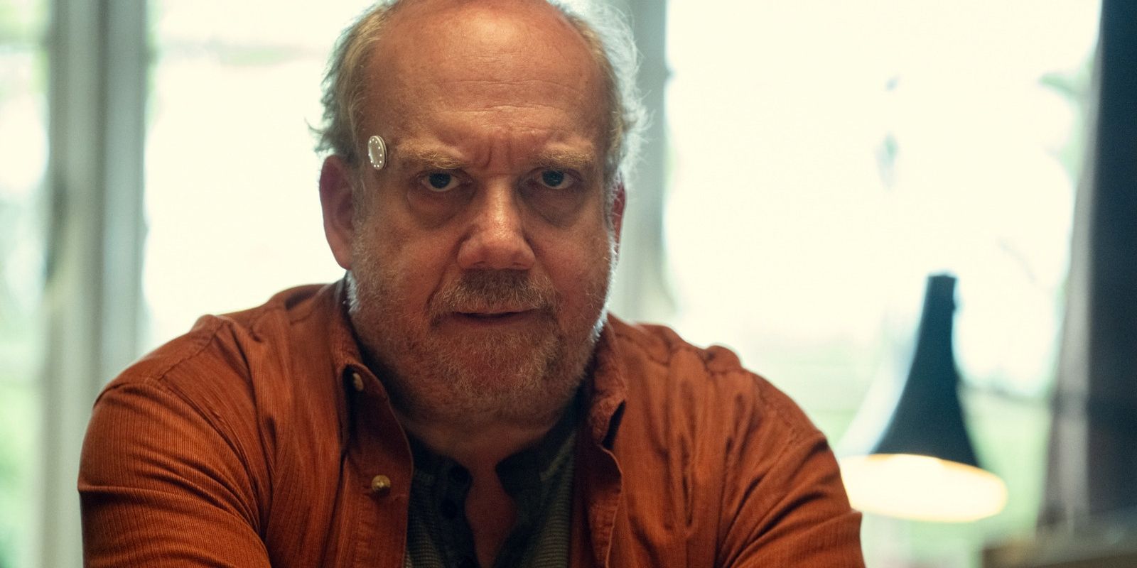 Phillip (Paul Giamatti) looks stressed with an electrode on his temple in Black Mirror's Eulogy.