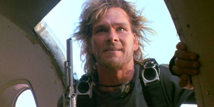 Bodhi holds a gun as he prepares to jump from a plane in Point Break 1991 