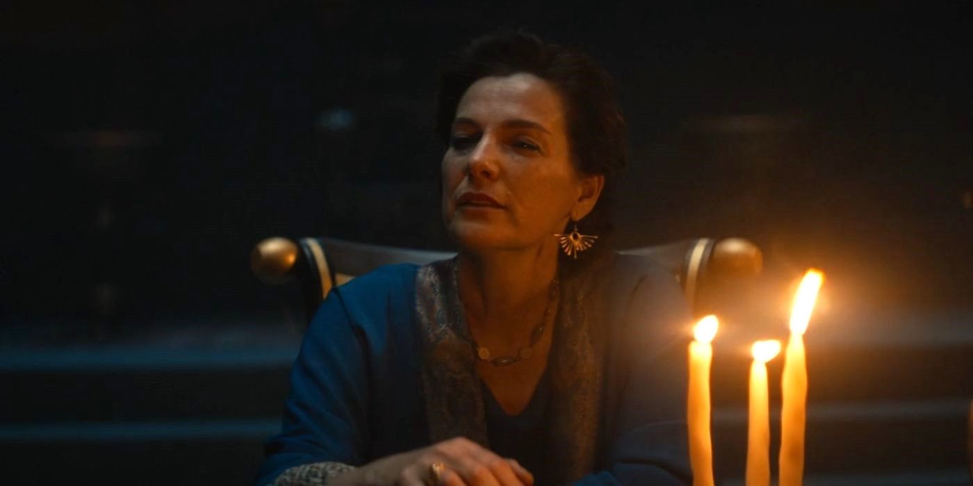 Ayelet Zurer as Queen Ahinoam sits at a table with candles alone in in House of David.