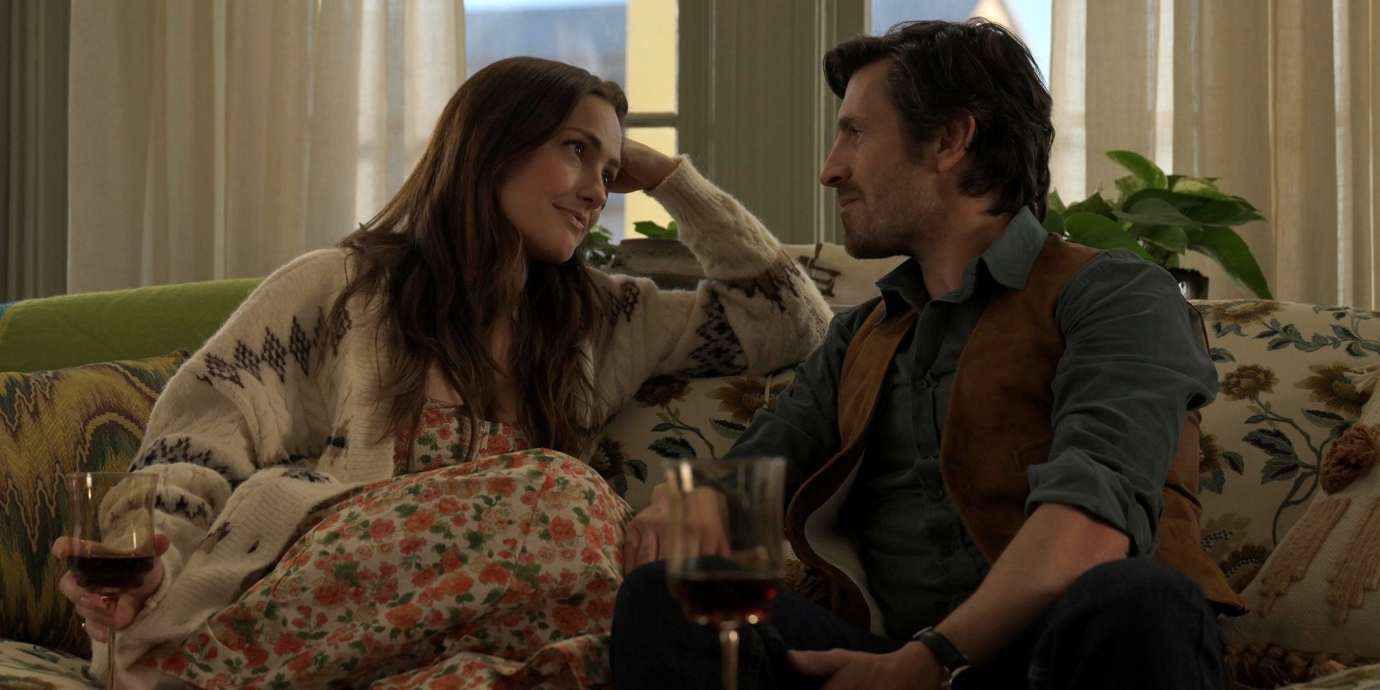 Eoin Macken as Davis Collins sitting on the couch with Minka Kelly as Quinn in Ransom Canyon