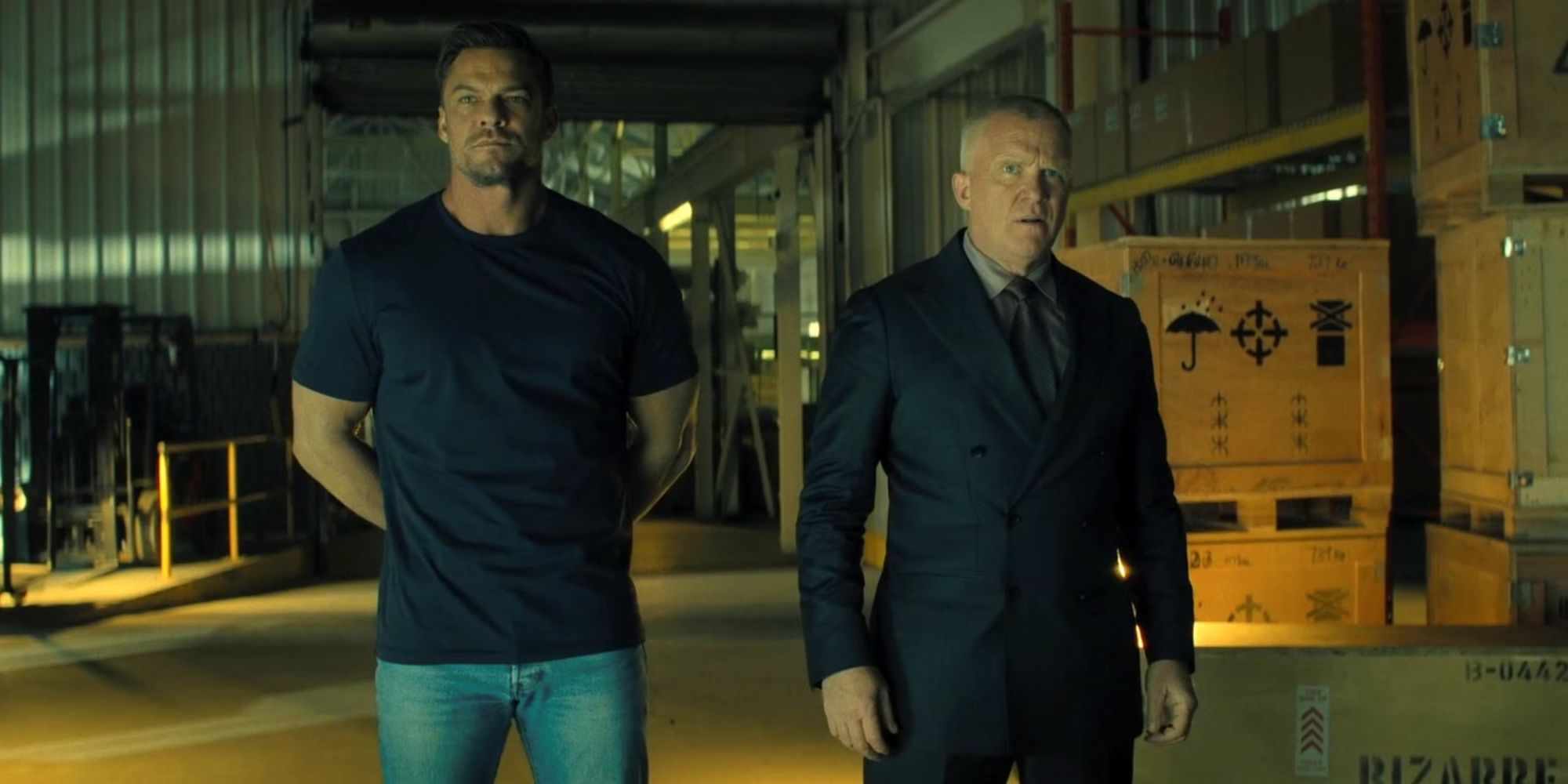 Alan Ritchson como Jack Reacher andando ao lado de Anthony Michael Hall como Zachary Beck na terceira temporada de Reacher.