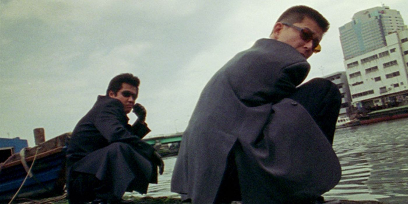Riki Takeuchi and Show Aikawa squatting on a rooftop and looking at the camera in Dead Or Alive