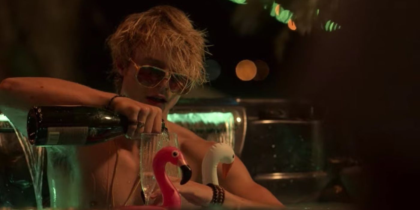 Rudy Pankow as JJ Banks wearing sunglasses and pouring a drink from a bottle in a hot tub in Outer Banks.