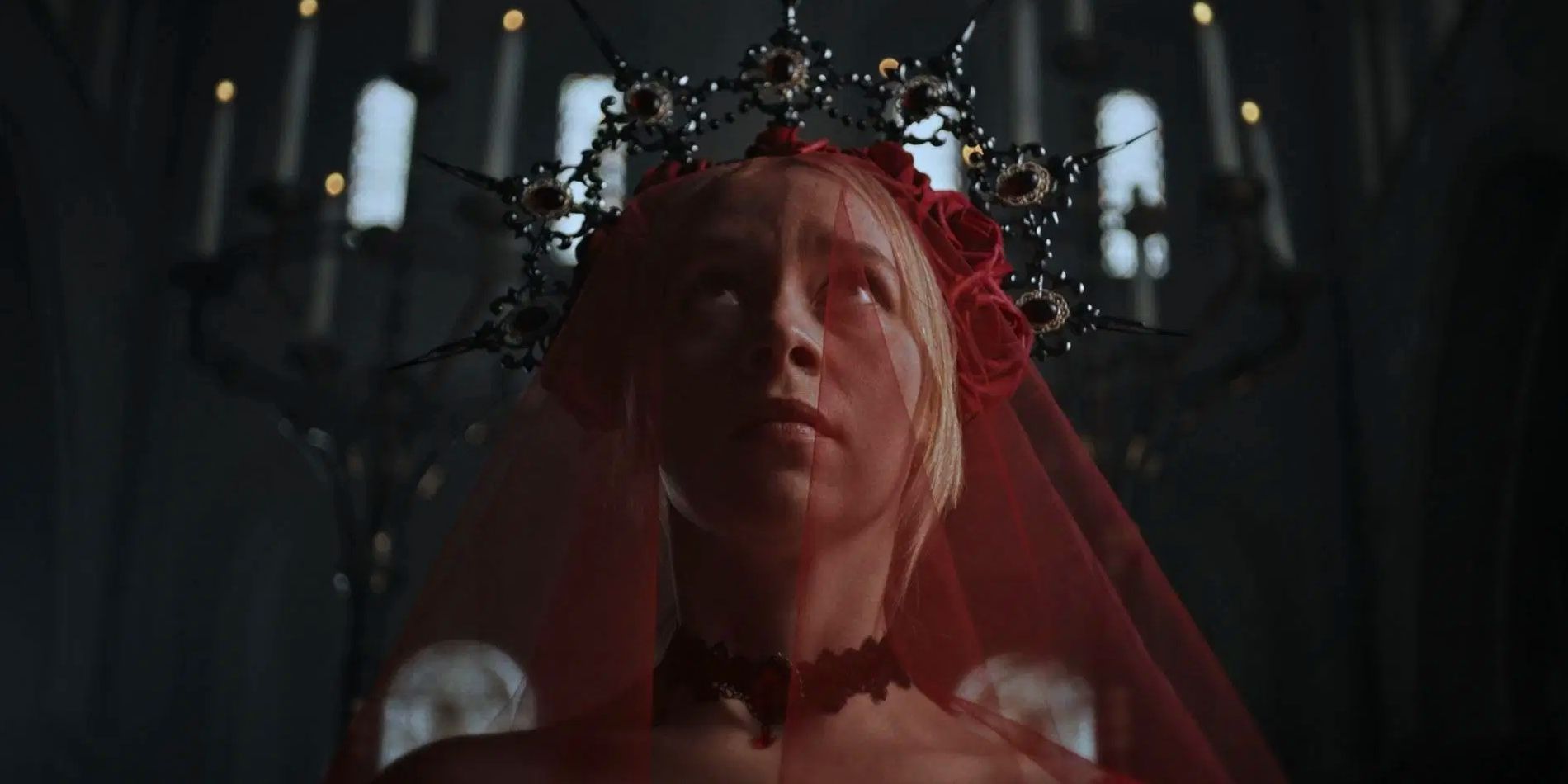 Actor Hannah Baxter-Eve as Evalina, looking upwards fearfully while wearing an intricate beaded crown with a red veil in Rumpelstiltskin.