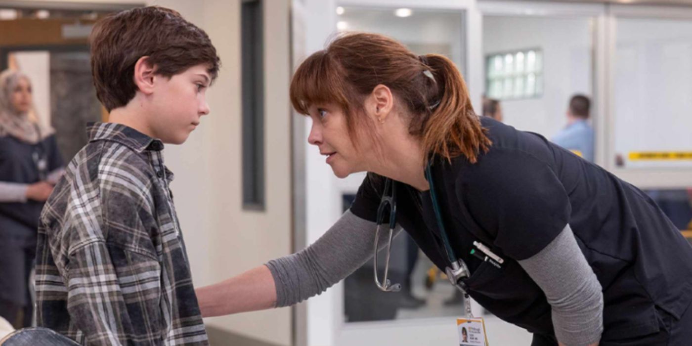 Fiona Dourif as Dr. Mckay wearing blue scrubs bending down to talk to her son in &lsquo;The Pitt.'