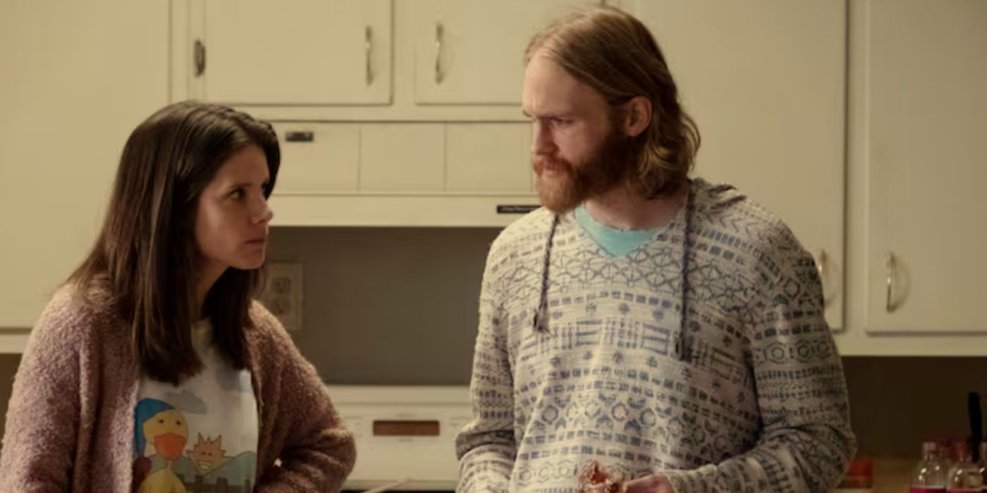 Sonya Cassidy and Wyatt Russell as Liz and Dud standing in the kitchen wearing sweaters in &lsquo;Lodge 49.'