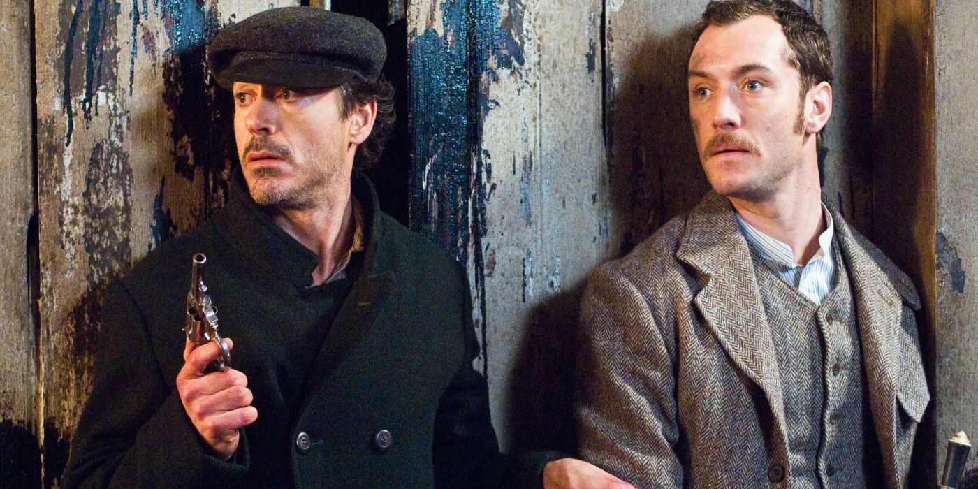 Robert Downey Jr.'s Sherlock standing against a wall and holding a gun with Jude Law's Watson in Sherlock Holmes