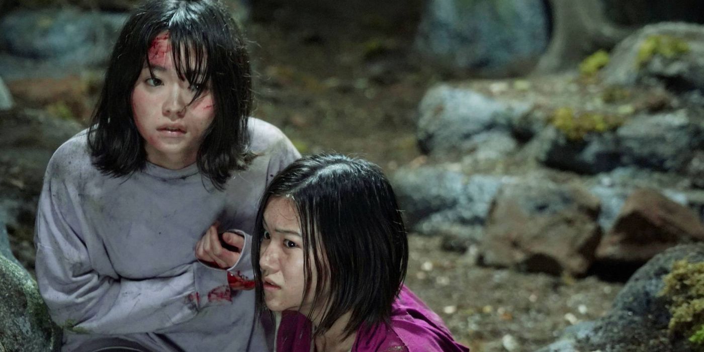 Two girls looking bloodied and dirty in the middle of an area with rocks and dirt in Suicide Forest Village aka Jukai Mura