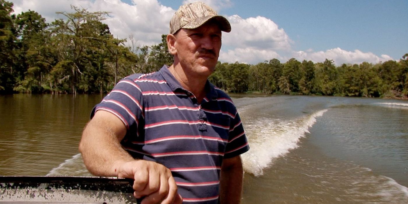 Troy Landry wearing a striped shirt on a boat on the water in 'Swamp People.'
