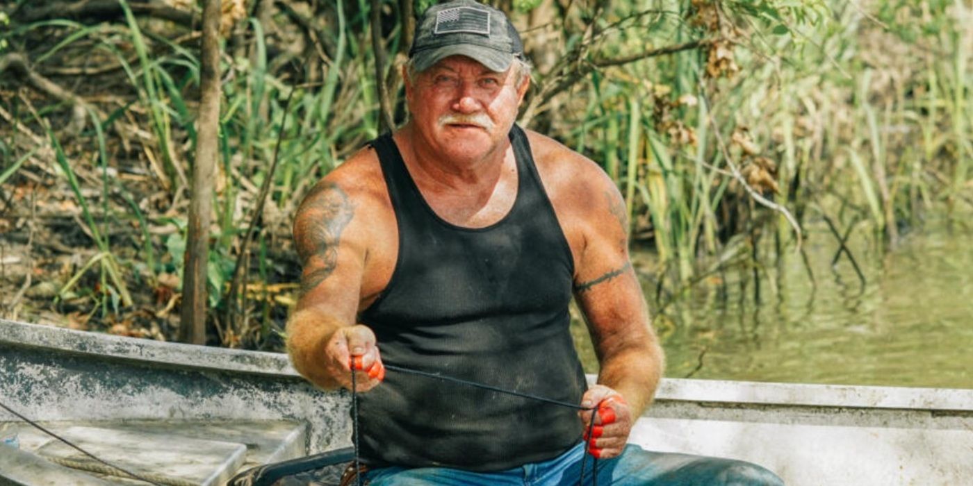 Terral Evans holding a thin line as he sits in a shallow boat in the bayou on Swamp People.
