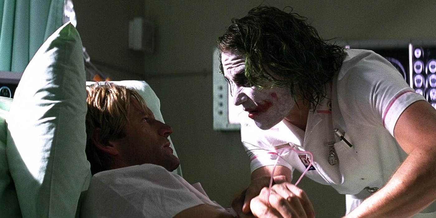 The Joker visits Harvey Dent and looms over his hospital bed in The Dark Knight