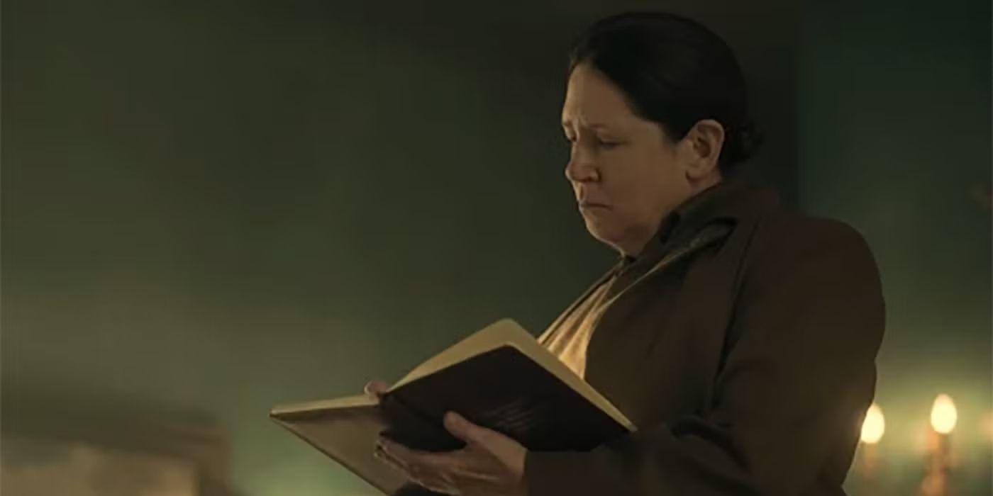 Ann Dowd as Aunt Lydia reading a religious text in a still from 'The Handmaid's Tale.'