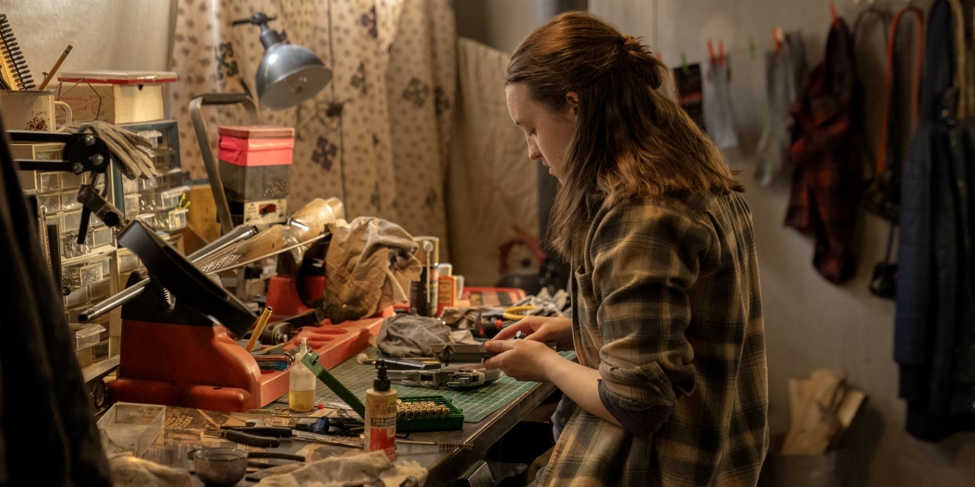 Bella Ramsey as Ellie tinkering at a work table in The Last of Us Season 2