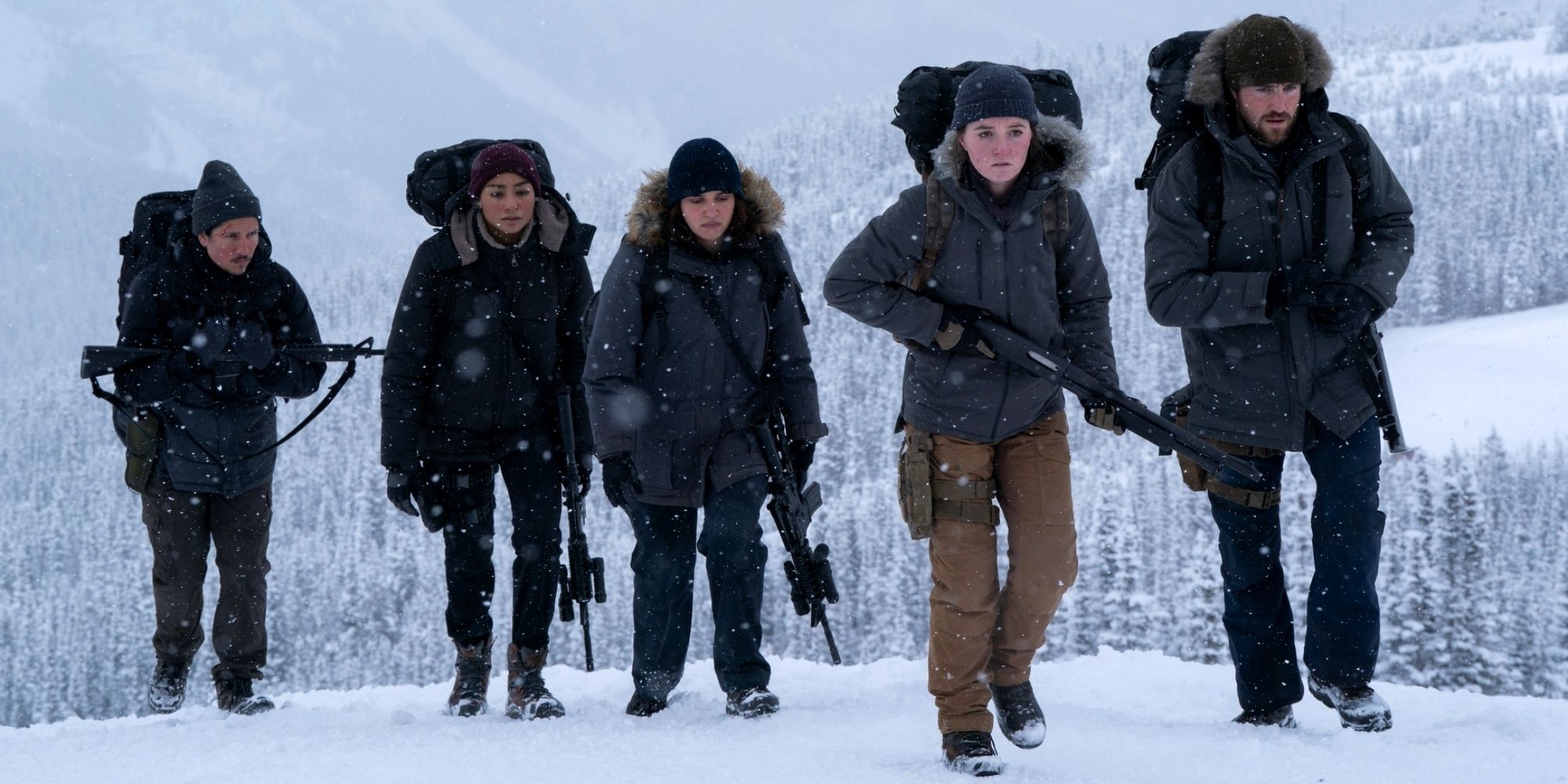 Kaitlyn Dever as Abby holding a shotgun as she leads four others over a snowy hill in The Last of Us Season 2