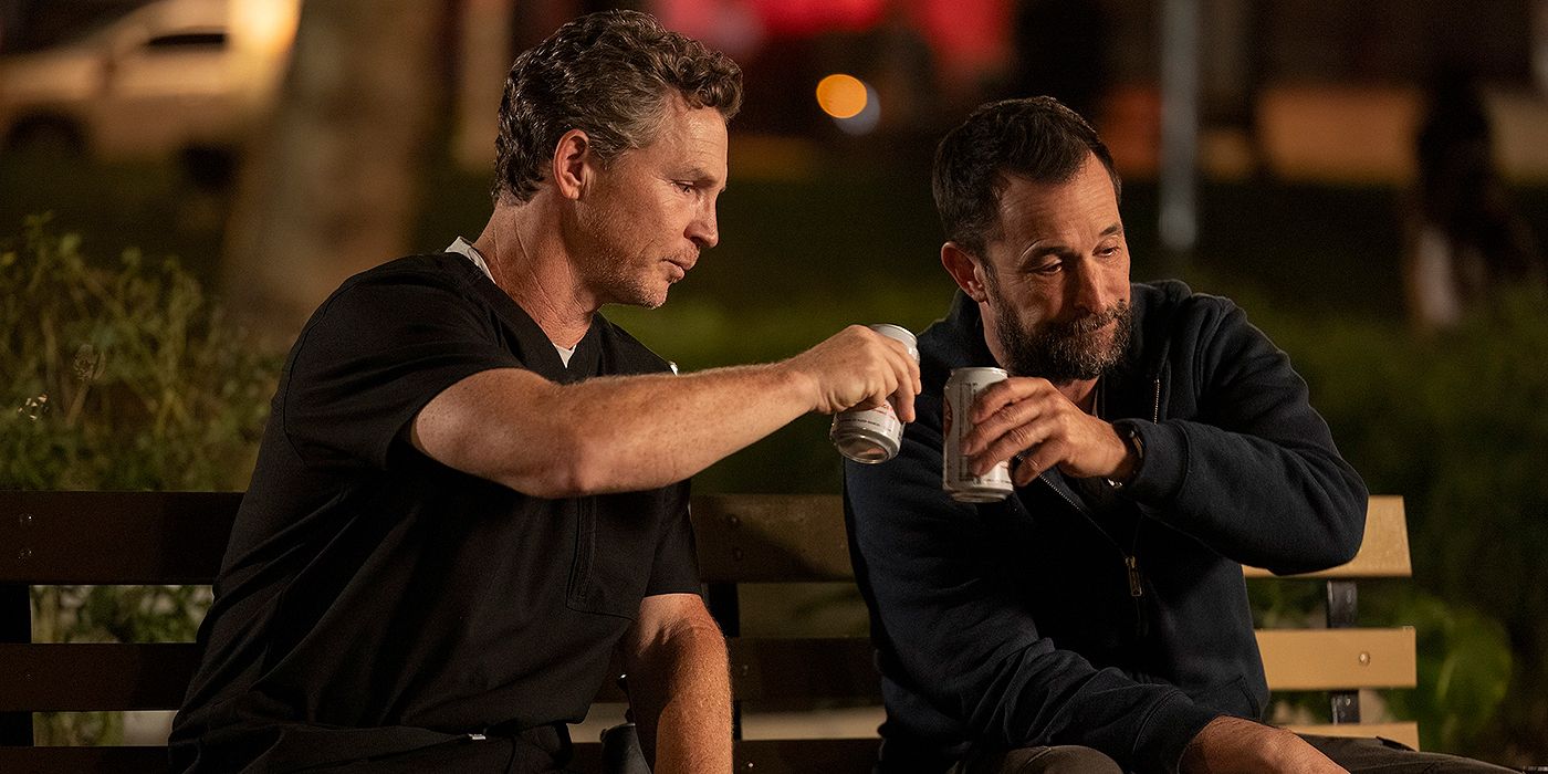 Shawn Hatosy as Dr. Abbot and Noah Wyle as Dr. Robby clinking beer cans in a park in The Pitt Season 1, Episode 15
