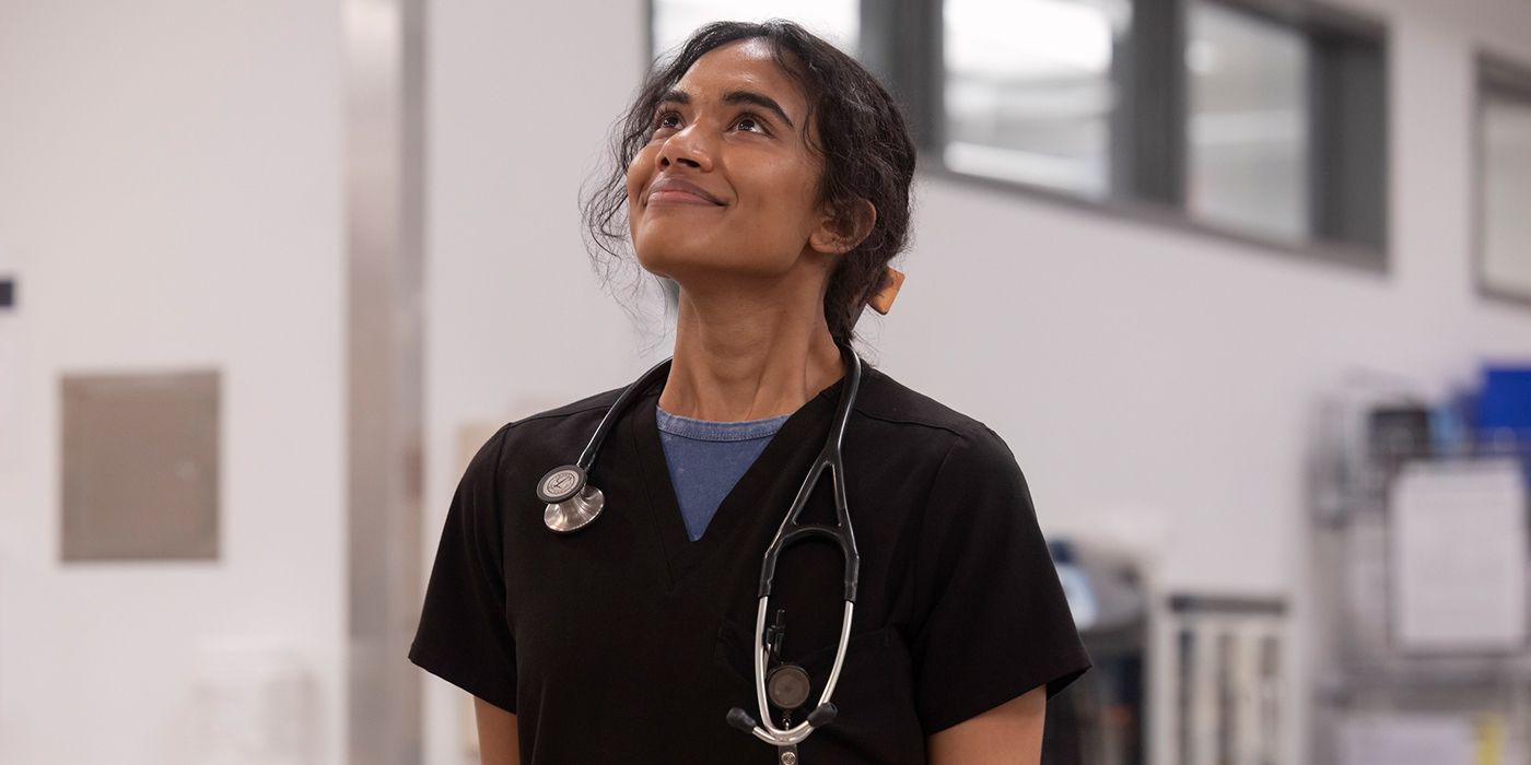 Supriya Ganesh as Dr. Mohan smiling up at the patient board in The Pitt Season 1, Episode 15.