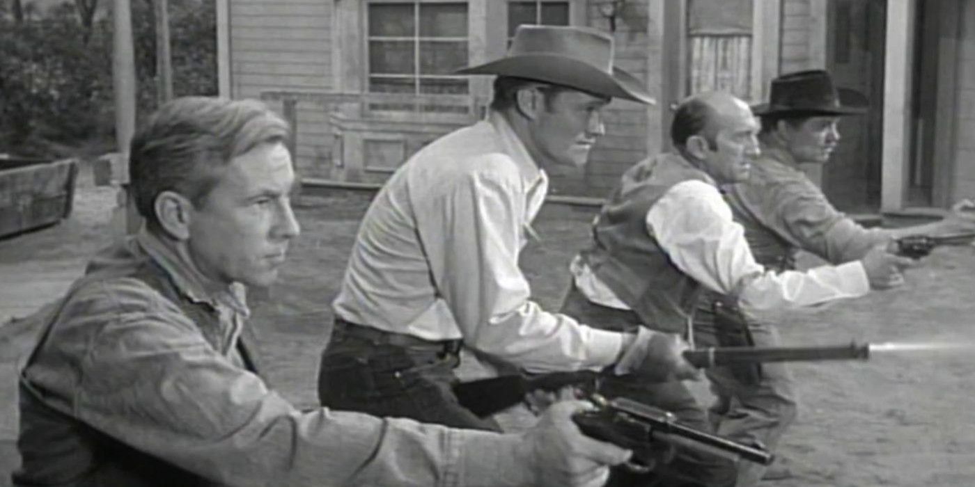 Lucas stands with other men in a line holding a gun in The Rifleman.