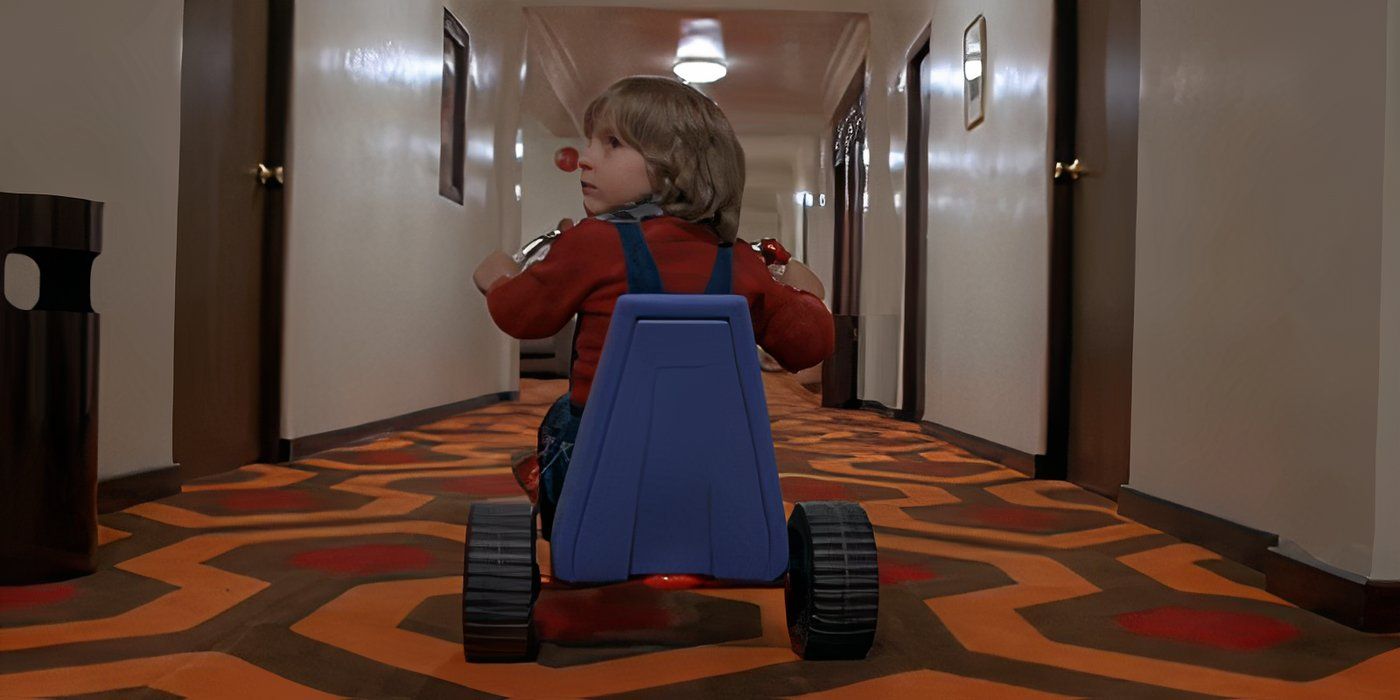 Danny (Danny Lloyd) turns his head to look behind him while sitting on his Big Wheel in The Shining (1980) dir. Stanley Kubrick
