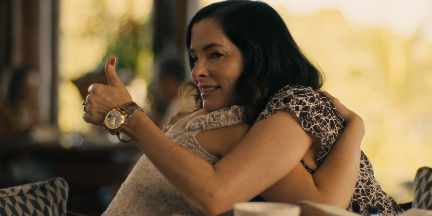 Victoria (Parker Posey) hugging Piper (Sarah Catherine Hook) while giving a thumbs upin The White Lotus Season 3 finale.