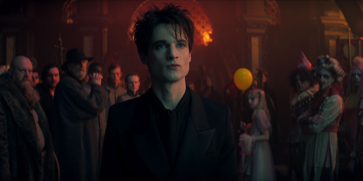 Tom Sturridge as The Sandman stands in front of an off-camera presence with onlookers behind in The Sandman