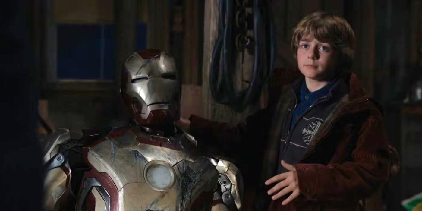 Ty Simpkins as Harley standing with the Iron Man armor in Iron Man 3.