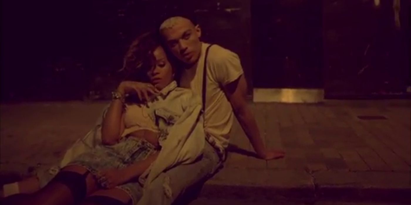 Rihanna leans into a man in the music video for We Found Love