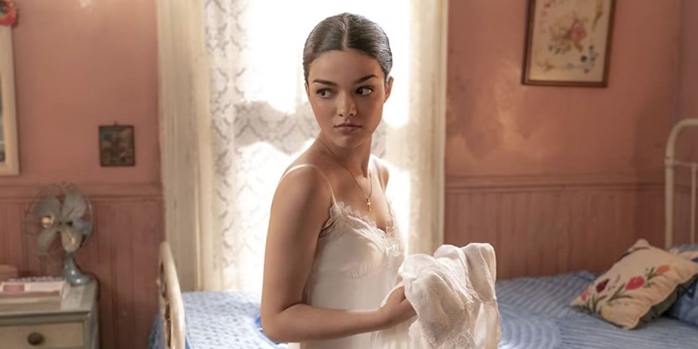 Rachel Zegler holding a white dress and looking deep in thought in West Side Story.