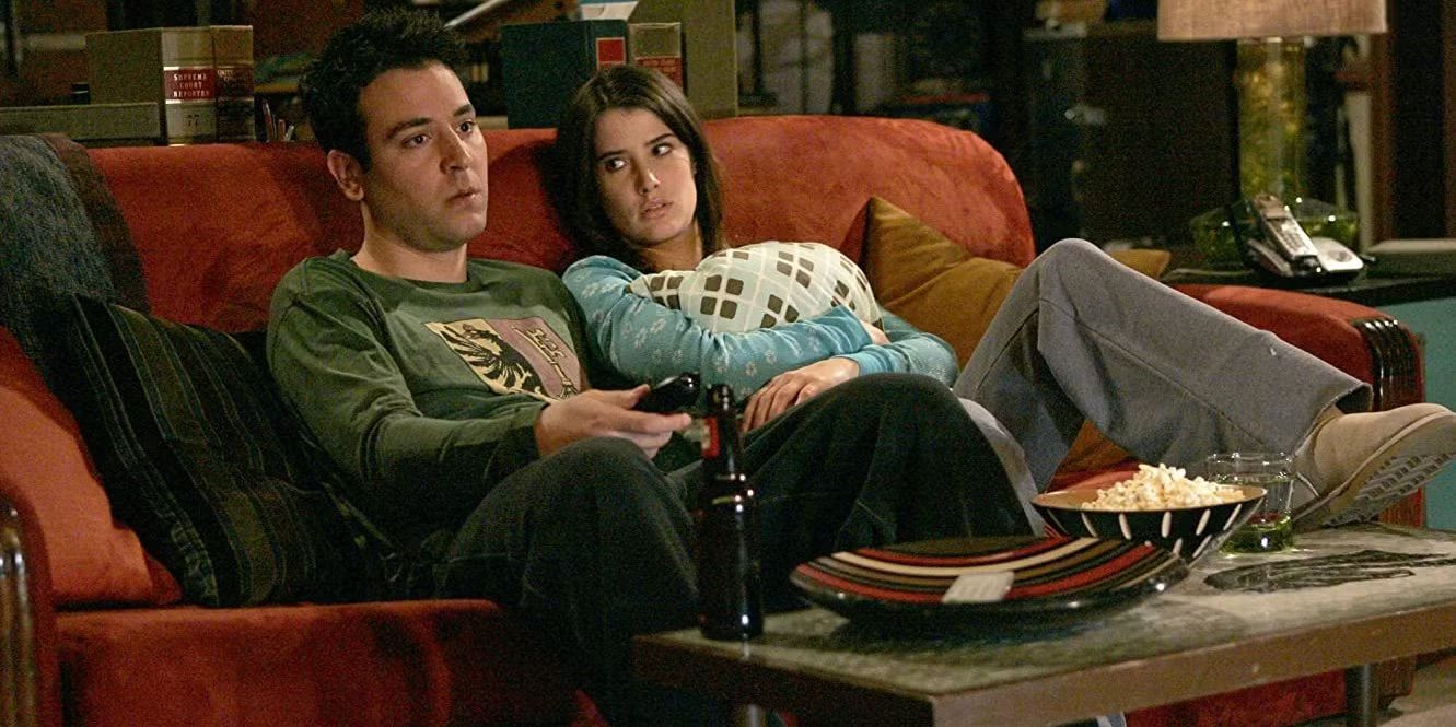 Ted and Robin sit on a couch looking upset in How I Met Your Mother "Stuff."
