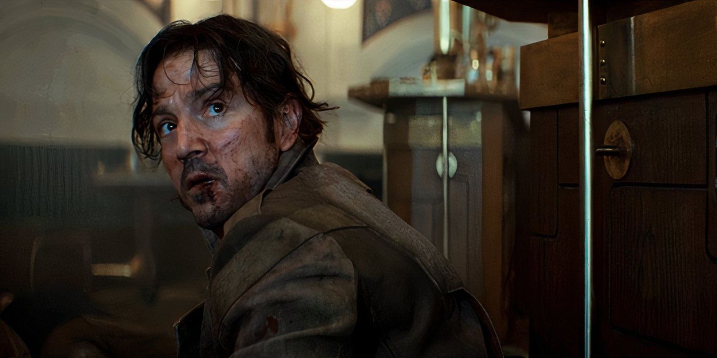 Cassian Andor (Diego Luna), his face bloody, looking up at an offscreen Syril Karn in Andor