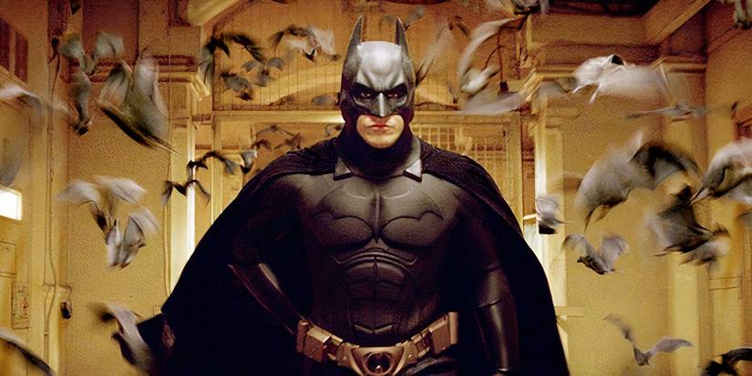 Christian Bale as Batman surrounded by bats in Batman Begins.