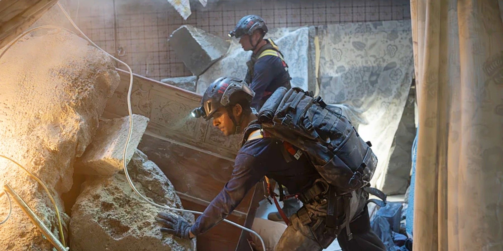 Buck and Ravi tending to a collapsed building in the Season 8 finale of 9-1-1