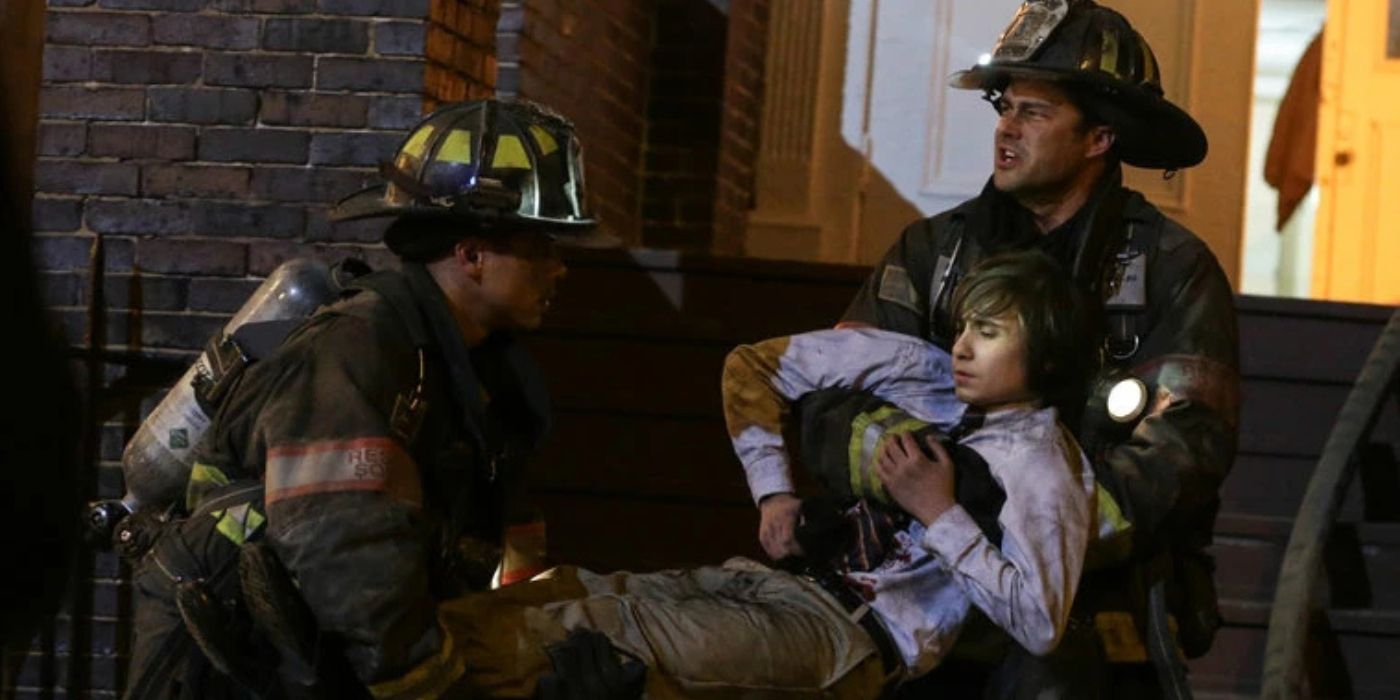 Taylor Kinney as Lieutenant Kelly Severide helps to carry an injured person on 'Chicago Fire.'