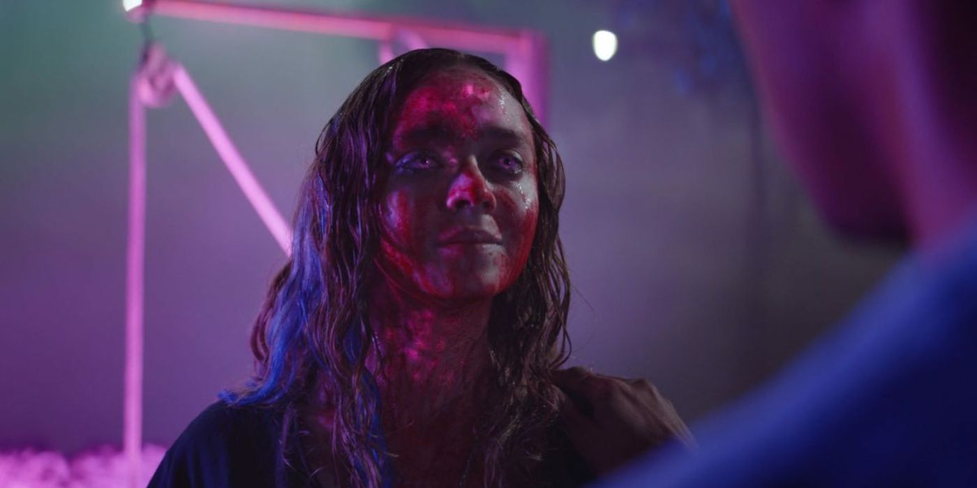 A woman with blood on her face smiling faintly in Color Out of Space