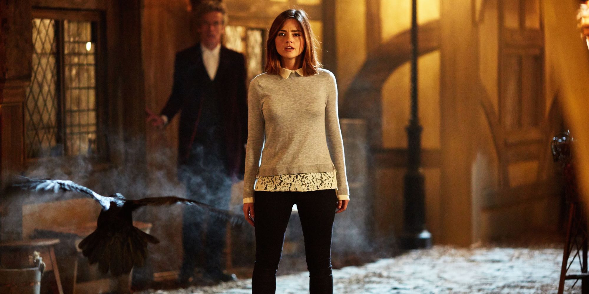 Clara (Jenna Coleman) faces a raven on a street while the Doctor (Peter Capaldi) looks on in Doctor Who.