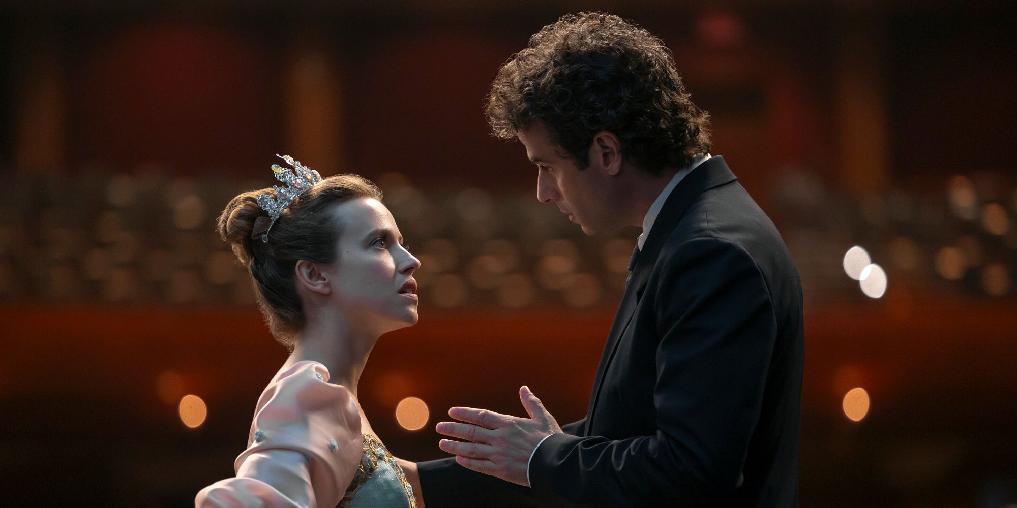 Luke Kirby as Jack facing Lou de Laâge as Cheyenne as they talk on an empty stage in Étoile
