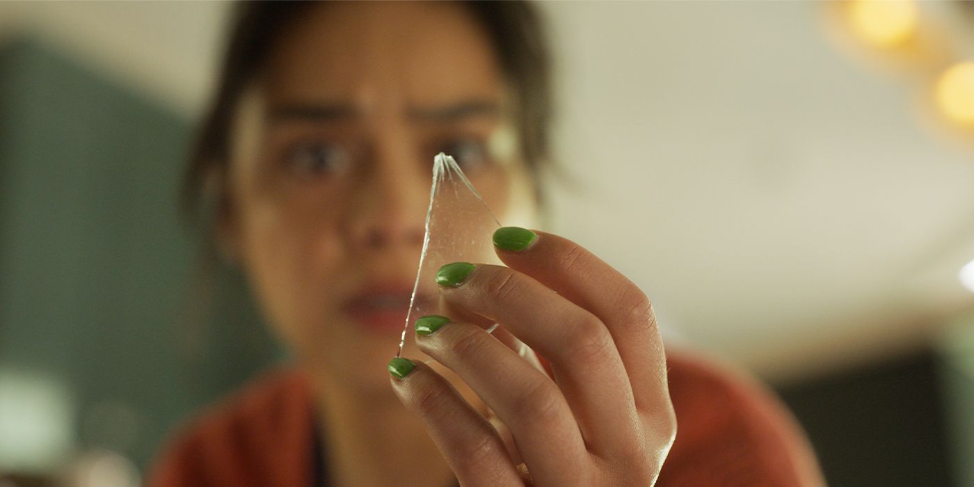 Kaitlyn Santa Juana worriedly holding a shard of glass in Final Destination Bloodlines