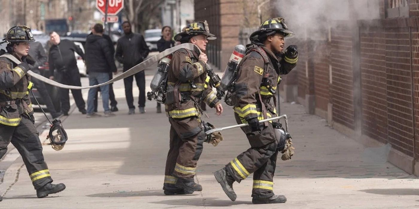 Herrmann (David Eigenberg) and Ritter (Daniel Kyri) drag hose to a building on fire in the Chicago Fire Season 13 finale.