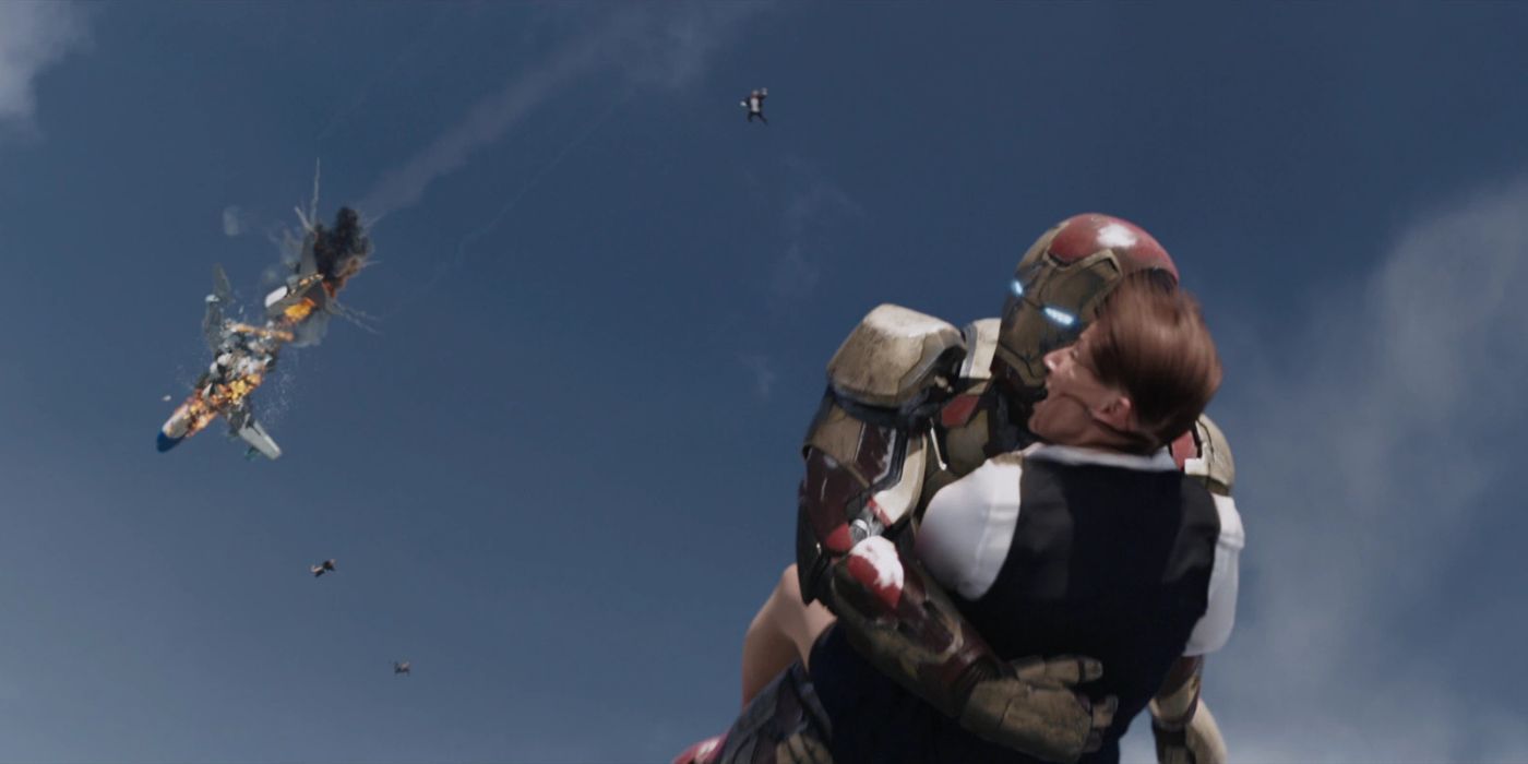 Iron Man holding a woman in midair as a plane explodes in Iron Man 3.