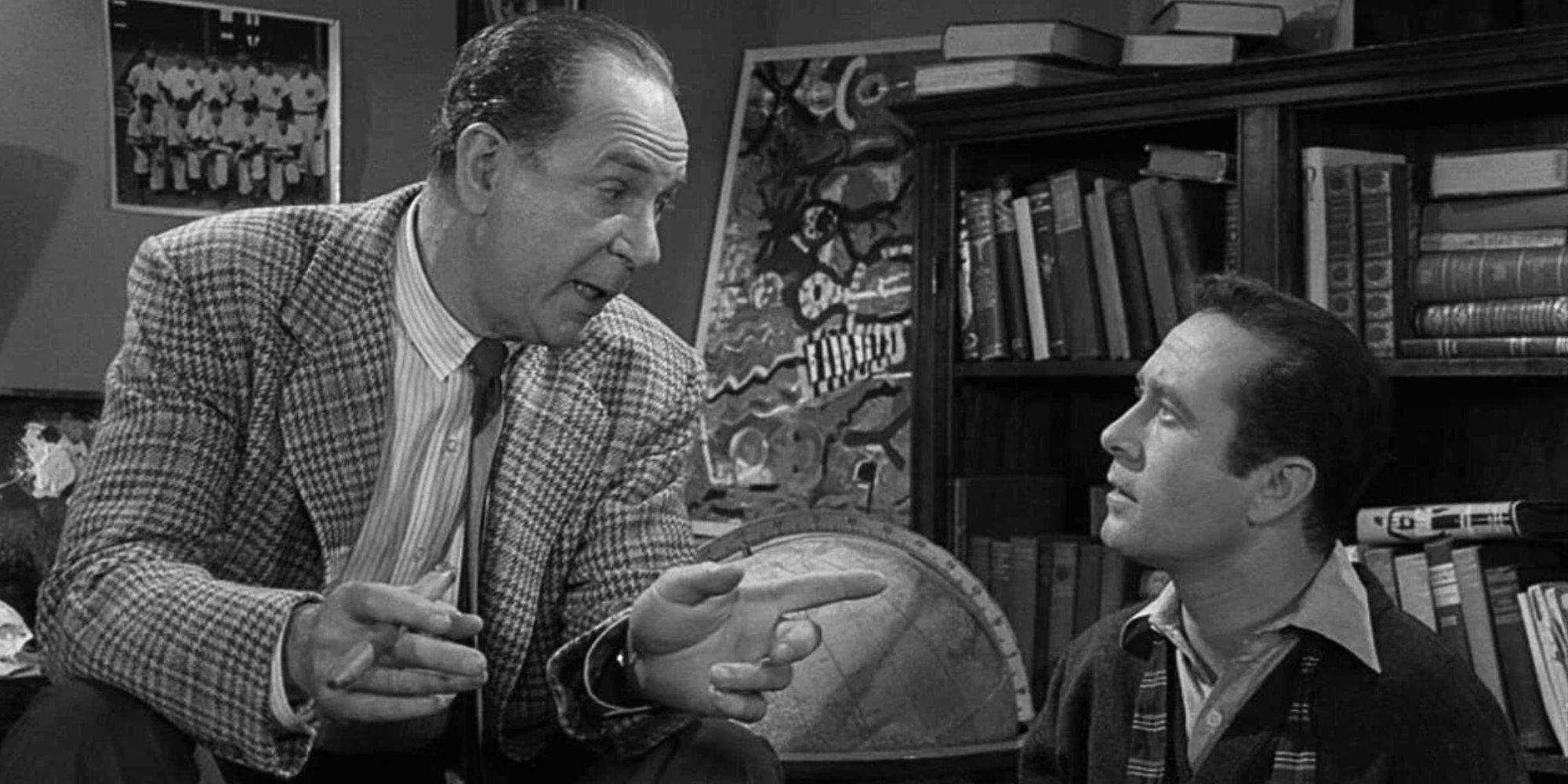 Jack Albertson sitting on the back of a couch looking down at Howard Morris sitting next to him in The Twilight Zone episode I Dream of Genie