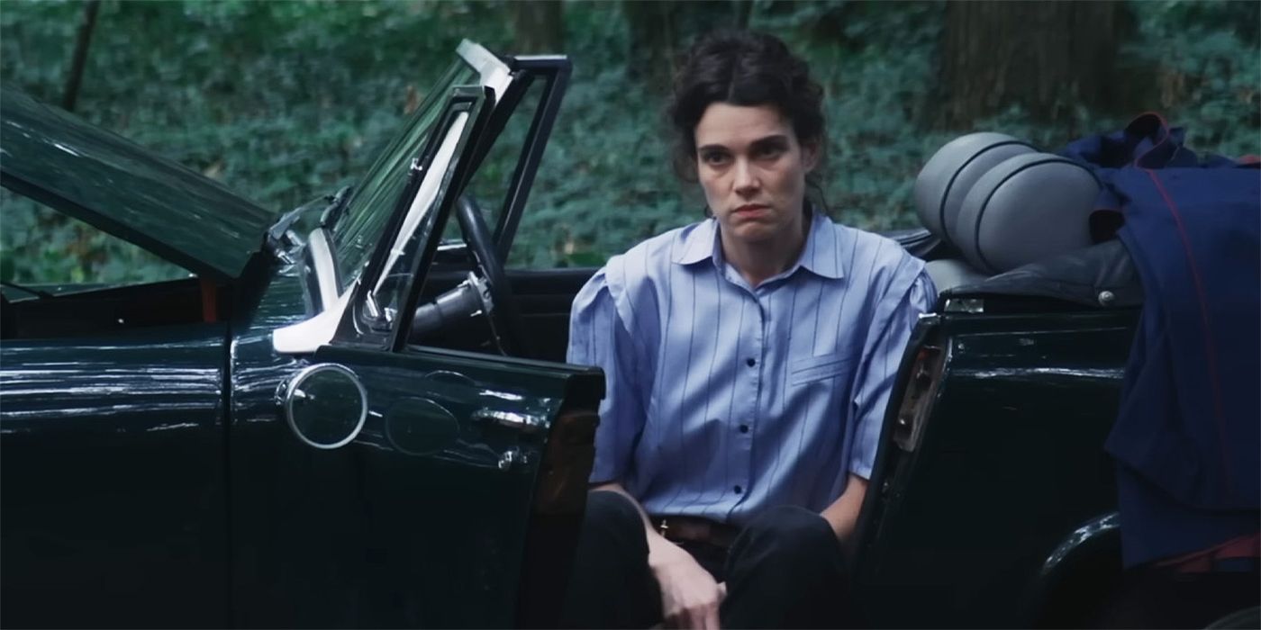 Camille Rutherford frowning and sitting in a broken down car in the woods in Jane Austen Wrecked My Life.