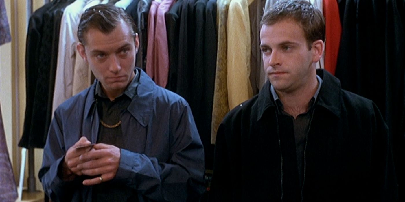 Jude Law stands next to another person in front of a clothing rack in Love, Honour and Obey.