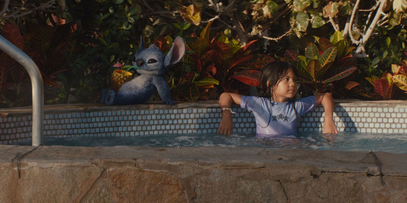 Maia Kealoha as Lilo, lounging in a hot tub while Stitch sips on a cocktail behind her in Lilo & Stitch
