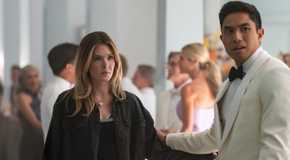 Meghann Fahy wearing a black jacket holding the arm of Trevor Salter wearing a white tuxedo in the Sirens finale