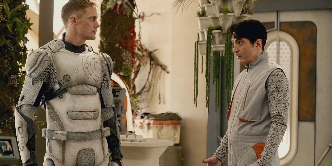 Murderbot (Alexander Skarsgard) e Gurathin (David Dastmalchian) em pé e conversando no episódio 2