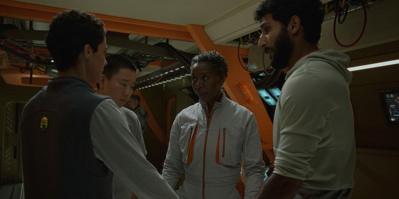 Mensah (Noma Dumezweni), Ratthi (Akshay Khanna), Pin-Lee (Sabrina Wu), and Arada (Tattiawna Jones) holding hands in a circle in Murderbot