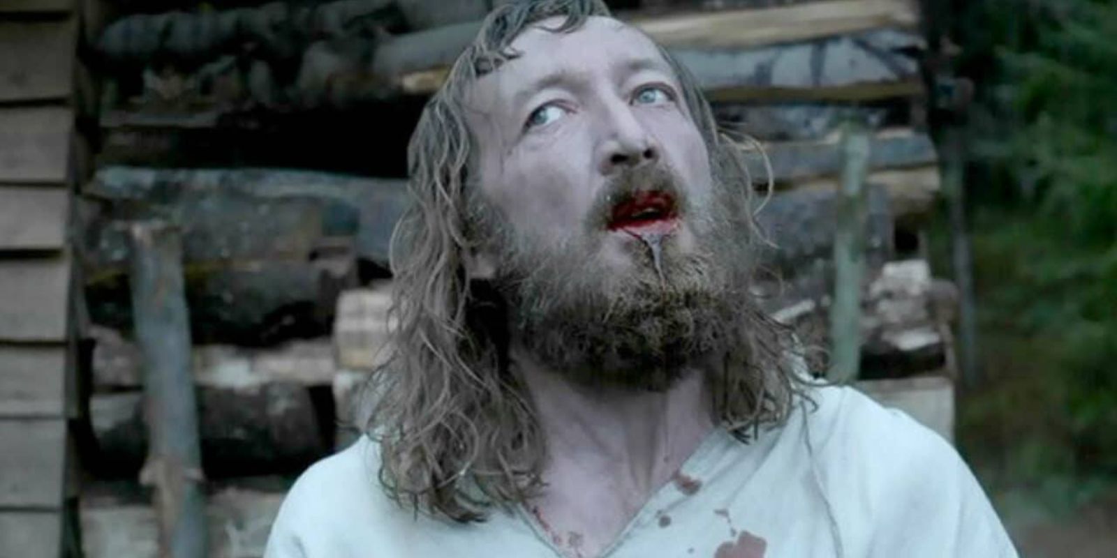 Ralph Ineson with blood coming out of his mouth in The Witch