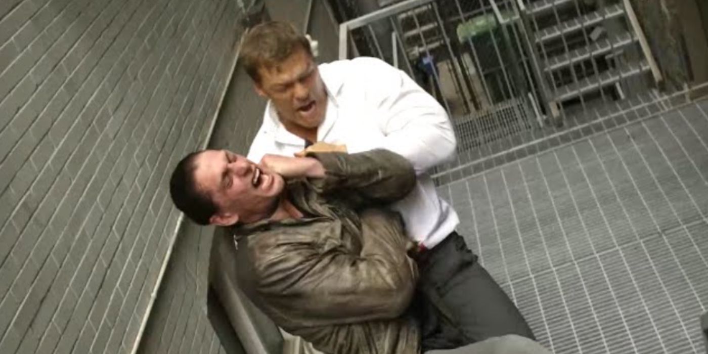 Alan Ritchson como Reacher usando uma camisa branca brigando em um beco com um homem em 'Reacher'.