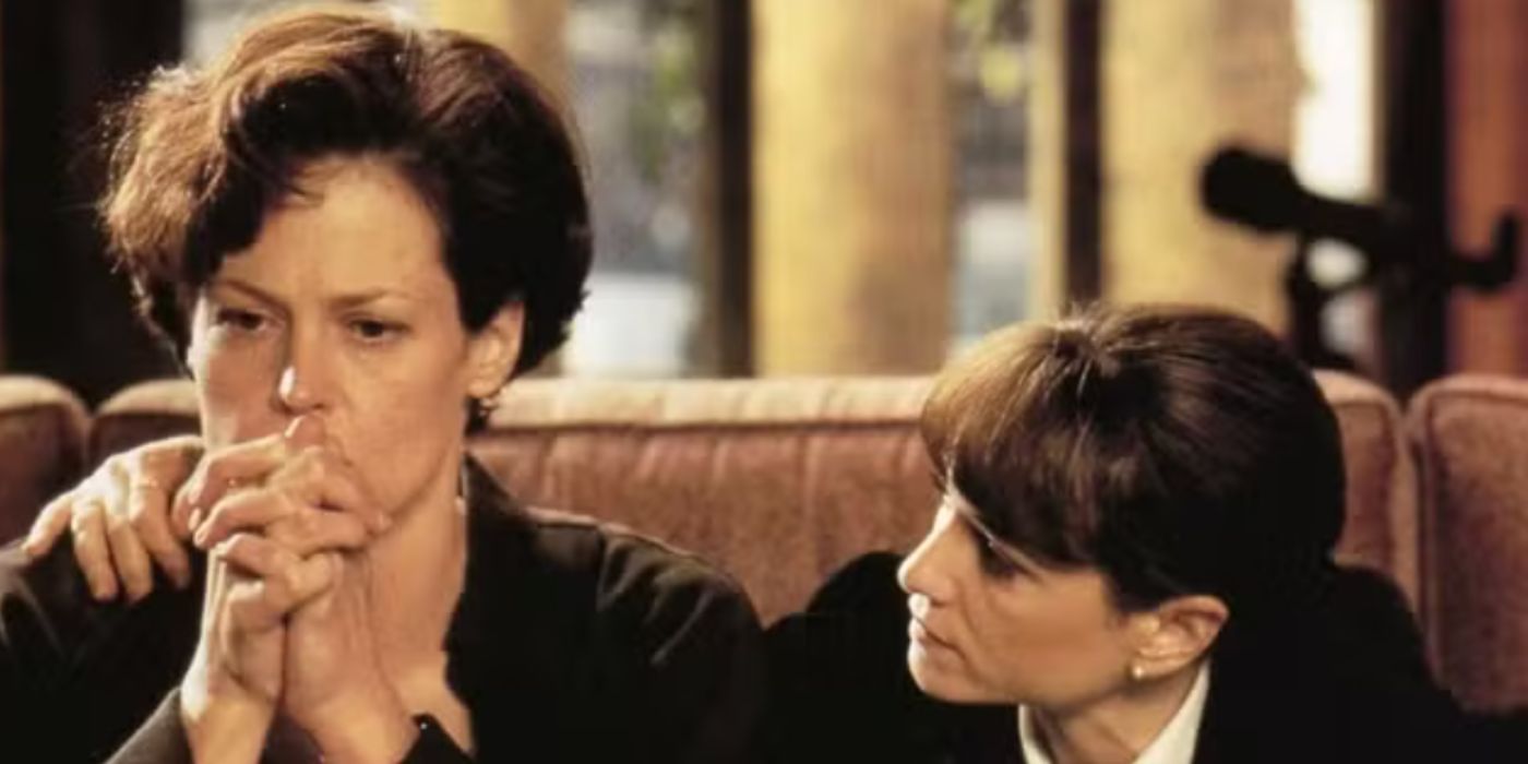 Sigourney Weaver and Holly Hunter as Dr. Hudson and Monahan sitting on a couch wearing black shirts in 'Copycat'