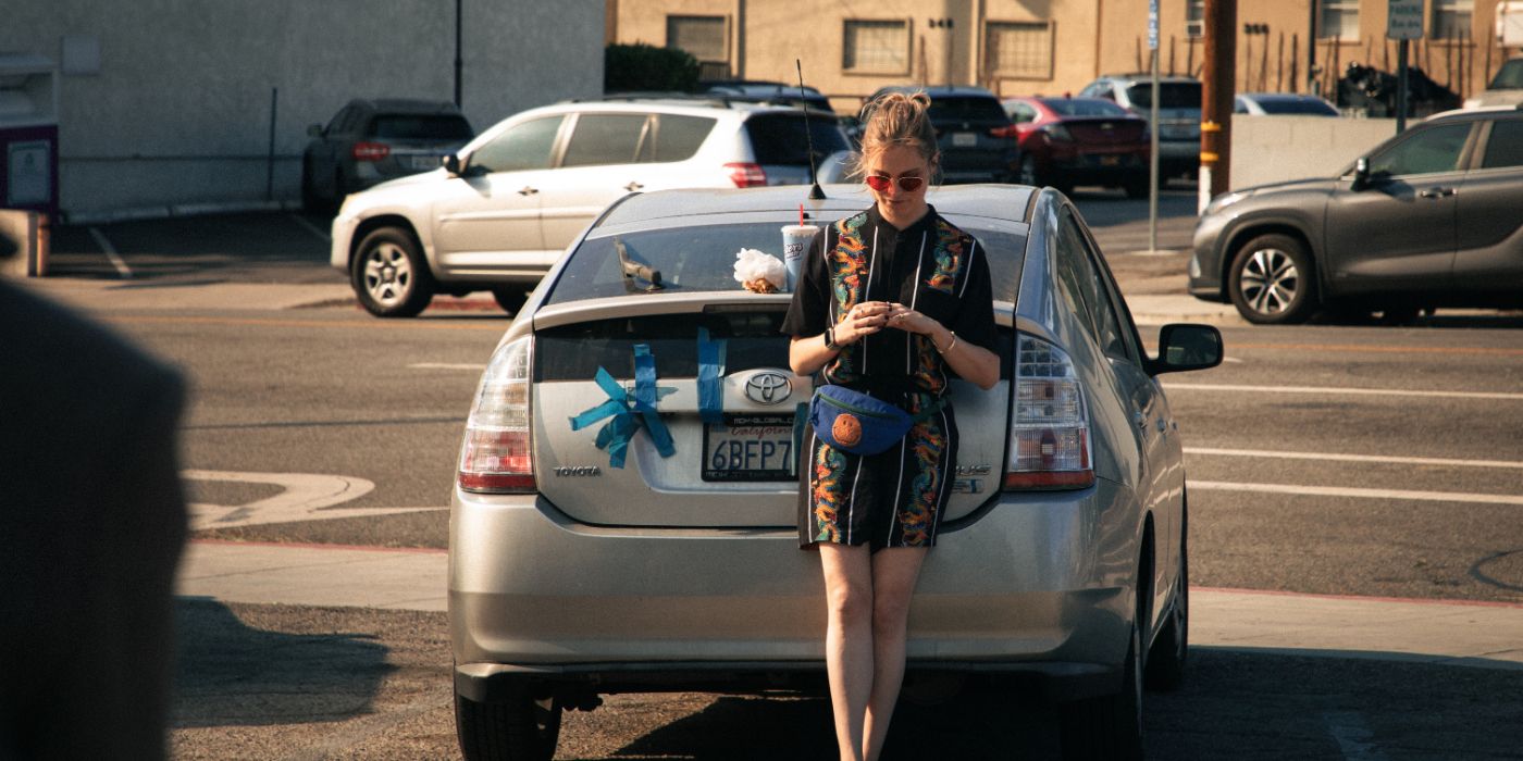Eliza Taylor leaning against a car in Status: Active